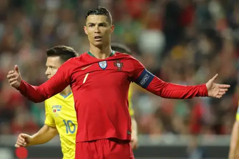 Cristiano Ronaldo w czerwonej koszulce Portugalii, z opaską "RESPECT", na tle drabinki rozgrywek Mistrzostw Europy w piłce nożnej.