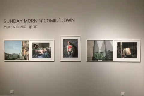 Utställning med Hannah Modighs verk "Sunday Mornin' Comin' Down". Bilder visar en stadsgata, en sovande person, en kvinna och en man.
