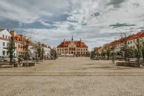 Ratusz i kolorowe kamienice na brukowanym rynku. Wspaniałe atrakcje turystyczne miasta, idealne na spacer.