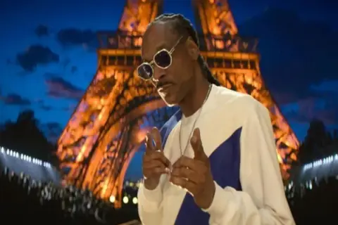 Snoop Dogg w Paryżu, jak z najlepszych filmów. W tle świecąca Wieża Eiffla.