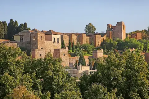 Malaga zamek, starożytna forteca z cegły i kamienia, wznosi się na wzgórzu pośród zieleni.