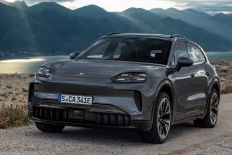 Nowy Porsche Cayenne 2025 w szarym kolorze, gotowy na przygodę wśród gór i jeziora.