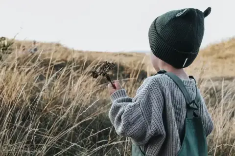 Jesienią w góry dziecko ubierz ciepło: czapka z uszkami, sweter i ogrodniczki.