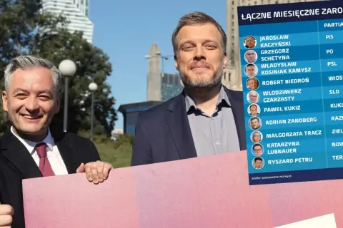 Dwóch polityków prezentuje tabelę z zarobkami liderów partii. Sprawdź, ile zarabia członek partii.