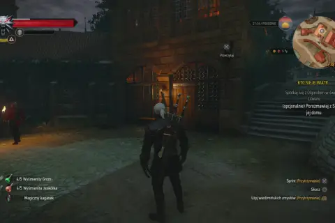Geralt stoi przed kamienną budowlą, gdzie czeka go serce z kamienia zakończenia misji. W tle widać strażnika z pochodnią.