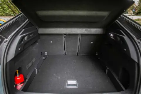 Pusta przestrzeń bagażowa Peugeot 3008, z widocznym gaśnicą. Wymiary bagażnika pozwalają na przewóz wielu rzeczy.
