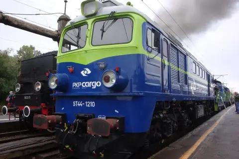 Lokomotywa ST44-1210 PKP Cargo, symbol Solidarności, dymi na tle parowozu.