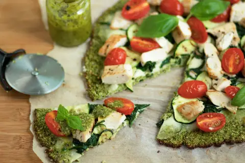 Pyszna pizza na spodzie z brokuła z kurczakiem, cukinią, pomidorkami i pesto.