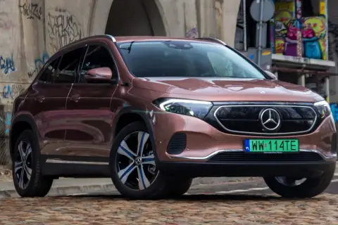 Różowy Mercedes EQA na tle graffiti.