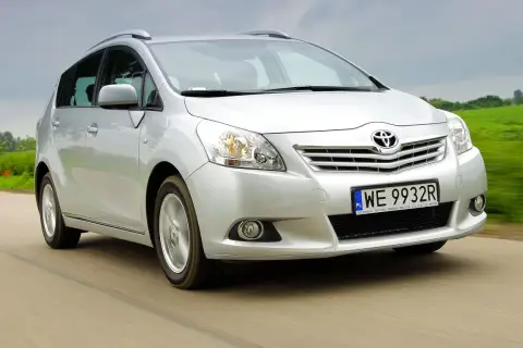 Srebrna Toyota Verso 1.8 benzyna w ruchu, z zielonym polem w tle.