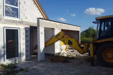 Budowa domu w toku. Koparka pracuje przy fundamentach. Czy wlz czy potrzebny projekt?