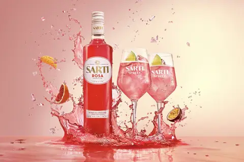 Sarti Spritz w towarzystwie owoców i orzeźwiających bryzgów. Idealny aperitif na letnie wieczory.