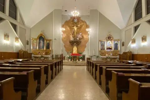 Wnętrze kościoła z ławkami i ołtarzem. Niech będzie pochwalony Jezus Chrystus.