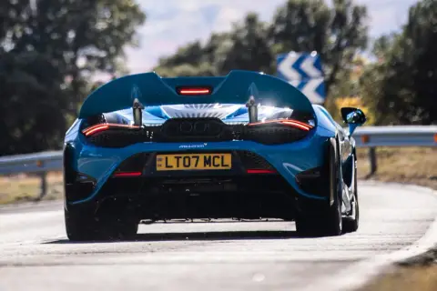 Niebieski McLaren 765LT z czterema końcówkami wydechu pędzi po zakręcie.
