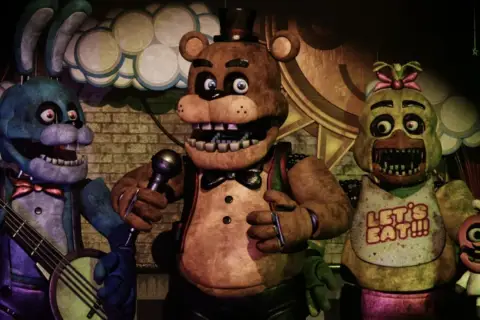 Freddy Fazbear i jego przyjaciele, Bonnie i Chica, występują na scenie.