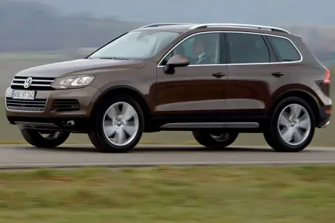 Brązowy Volkswagen Touareg w ruchu. Ten model to jeden z najmniej awaryjnych SUV-ów 10 letnich, idealny na długie podróże.