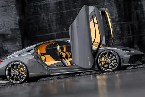 Szary Koenigsegg Gemera z otwartymi drzwiami i żółtym wnętrzem. Poznaj Koenigsegg Gemera cena i możliwości tego cudu techniki.