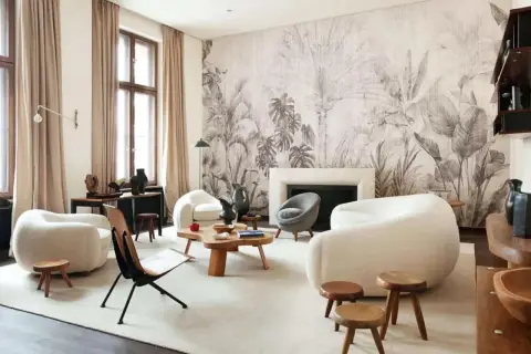 Nowoczesny salon z sofami w kształcie chmur i egzotyczna tapeta z motywem roślinnym tworzą przytulną atmosferę.