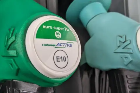 Dwie dysze dystrybutorów paliwa. Zielona dysza z napisem "euro super Pb 95 z technologią ACTIVE E10". Obok turkusowa dysza z napisem "E5".