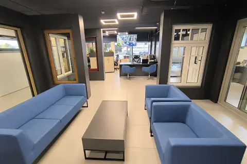 Nowoczesne wnętrze salonu okien i drzwi z niebieskimi sofami i stolikiem.