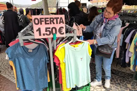 En el mercadillo de Gandía, una mujer busca ofertas. Ropa a 1,50€ en un puesto.