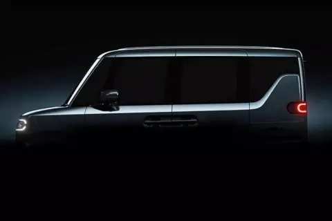 Ciemny, nowoczesny **Daihatsu** z charakterystycznym światłem tylnym w kształcie litery C i futurystycznymi światłami z przodu.