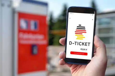 Smartphone zeigt D-Ticket App mit Preis und Kaufbutton. Verschiedene Deutschlandticket zahlungsarten sind möglich.