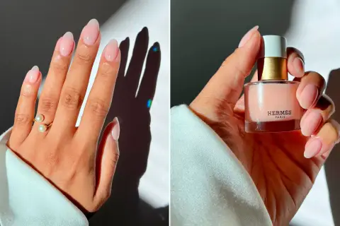 Manicura elegante con uñas nude, anillo de perlas y esmalte de uñas de Hermès.