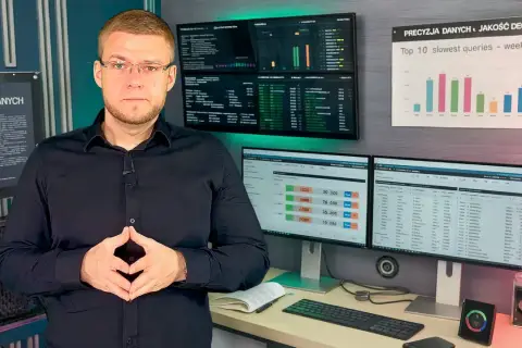 Mężczyzna w okularach przed ekranami z wykresami i danymi. Analiza danych, optymalizacja zapytań **sql**.