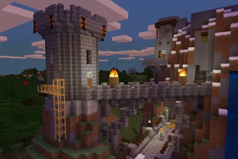 Kamienna twierdza w Minecraft, zbudowana na zboczu góry. Widać wieże, mosty, pochodnie i wodospad. Gra wymaga kreatywności!