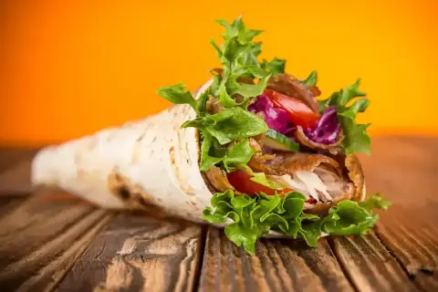Pyszny kebab w tortilli, pełen mięsa, warzyw i sosu. Idealny na szybki posiłek, choć warto pamiętać o jego tortilla kcal.
