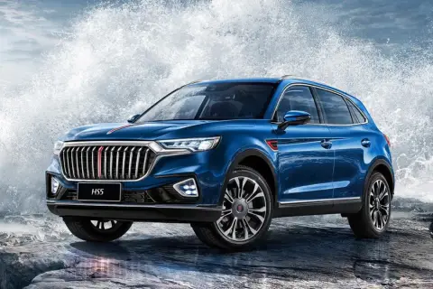 Niebieski Hongqi H5 na skalistym wybrzeżu, z potężnymi falami rozbijającymi się za nim.