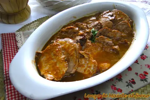 Arrosto di maiale morbido con sughetto in pentola, pronto per essere gustato.