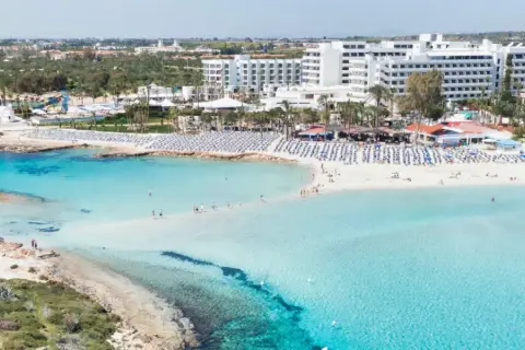 Piękna plaża z turkusową wodą i białymi hotelami. Czy Cypr to państwo, które oferuje takie widoki? Tak, to raj dla turystów!