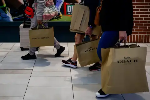 Ludzie z torbami na zakupy, w tym z torbami marki COACH. Udane zakupy w firmie, która oferuje stylowe produkty.