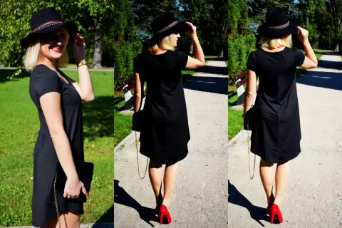 Elegancka czarna sukienka i czerwone szpilki tworzą stylowy zestaw. Kobieta w kapeluszu spaceruje po parku.