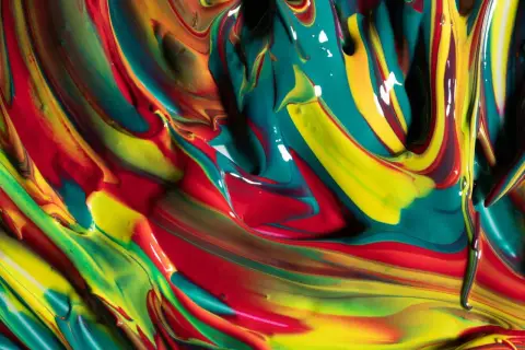 Fließende Farben: Rot, Gelb und Türkis, die sich zu einer lebendigen Mischung vereinen. Hier wird gezeigt, was sind die grundfarben.