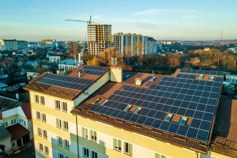 Panele fotowoltaiczne na dachu bloku mieszkalnego. Fotowoltaika we wspólnocie mieszkaniowej to przyszłość zielonej energii.