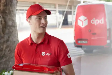 Kurier DPD z paczką w czerwonym opakowaniu, obok czerwonego vana. Czy to uszkodzona paczka DPD?