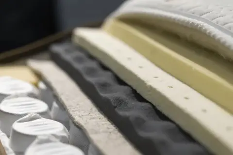 Schnitt durch eine Matratze mit verschiedenen Schaumstoffschichten und Federn.