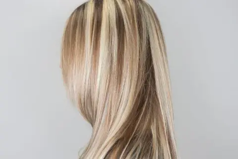 Kobieta z pasemkami blond na prostych włosach.