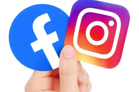 Palec trzyma loga Facebooka i Instagrama. Czy kopiowanie zdjęć z Facebooka jest karalne?