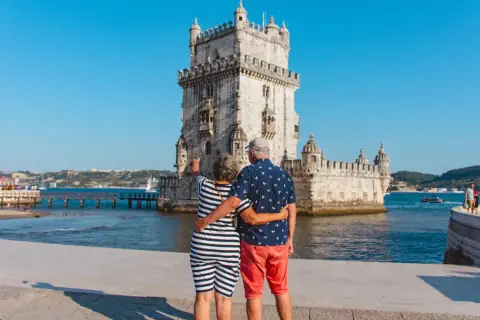 Pareja disfrutando de sus vacaciones en Portugal, admirando la Torre de Belém en Lisboa.