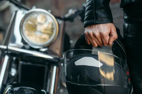 Motociclista con casco negro, listo para aprender como dar de baja una moto.