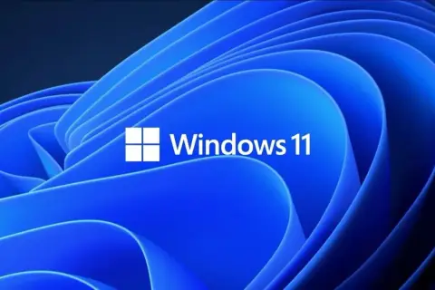 Niebieskie, faliste tło z białym logo i napisem "Windows 11". Ten klucz Windows 11 otwiera drzwi do nowoczesnego systemu.