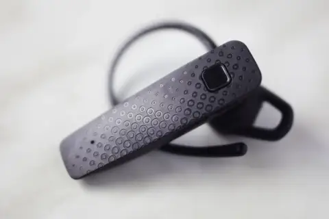 Czarna słuchawka Bluetooth z wzorem kółek. Dowiedz się, jak połączyć słuchawki Samsung z telefonem.