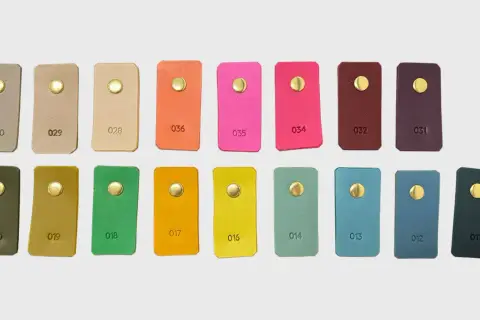 Échantillons de cuir aux teintes variées, du beige au prune, en passant par des couleurs vives comme le rose et l'orange. Chaque pièce présente une couleur de cuir distincte.