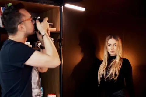 Fotograf robi zdjęcie modelce, tworząc idealne podświetlenie obrazu.