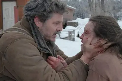Joel w śnieżnej scenerii, z krwawymi śladami na twarzy, trzyma za podbródek rannego Ellie. To mocna scena, która pokazuje, jak ważna jest obsada w budowaniu napięcia.