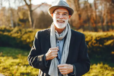 Uśmiechnięty starszy pan w kapeluszu i szaliku, jakby z mojego snu o zmarłym ojcu.